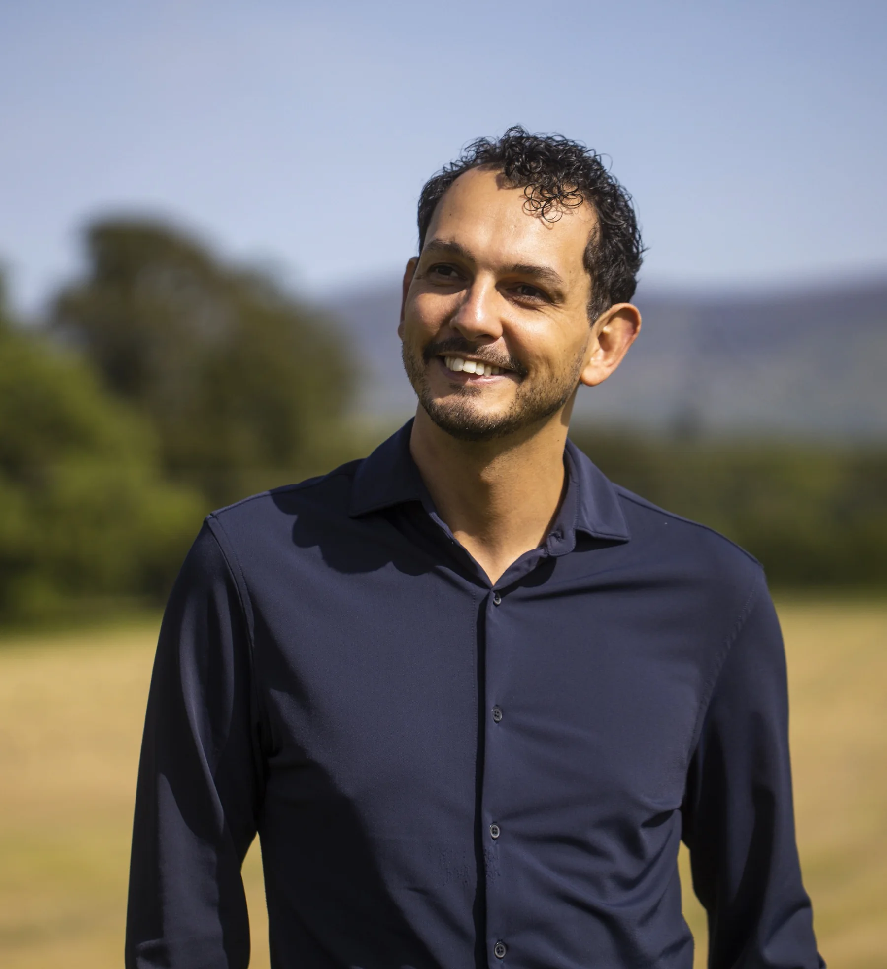 Daniel Pereira smiling outdoors in a navy shirt
